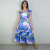 Mulher usando vestido longo Felicia Hortências com estampa de flores hortênsias em tons de azul e lilás