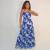 Mulher usando vestido longo Giovana com estampa floral azul em fundo branco