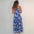 Mulher vista de costas usando vestido longo Giovana Max com estampa floral azul e alças finas