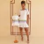 Mulher usando vestido curto branco com estampa poá e faixas coloridas, ao lado de vestido infantil idêntico em manequim