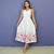 Mulher vestindo vestido mídi branco com estampa floral colorida na barra, modelo Jessica tal mãe tal filha