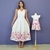 Vestidos tal mãe tal filha brancos com estampa floral colorida na barra, vestido midi feminino e vestido infantil com laço rosa no peito