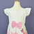 Vestido infantil branco com estampa floral colorida na parte inferior e laço rosa central na cintura