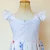 Detalhe das costas de vestido infantil branco com estampa floral colorida e alças com babados