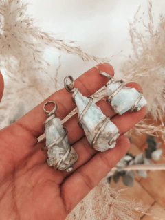 Dijes artesanales de cristales de celestina en órbitas de alambre de alpaca. 