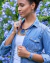 Mujer con camisa de jean exhibiendo un importante collar con dije de vitro fusión en distintos tonos de azul