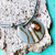 Collar femenino Aloha en tono gris con un dije redondo de vidrio y detalles plateados
