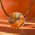 Collar de mujer color camel y naranja con dije hecho en vitro fusion
