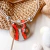 Collar femenino Aloha en tono coral y natural con un dije redondo de vidrio y detalles plateados