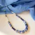 Collar de piedras  semipreciosas en tonos azules, con cuentas de piedra y cristal de diferentes formas y texturas.