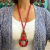 Collar color rojo, largo de cordones y dije 