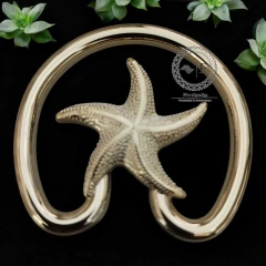 Fivela modelo estrela em ABS na cor dourada, com design decorativo de estrela do mar.
