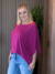 Mulher usando a Blusa Gabi Lisa de cor violeta, com calça jeans, em ambiente interno.