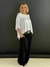 Cinto Boho Chic preto com detalhes metálicos prateados em uma pessoa vestindo roupa preta e branca.