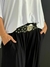 Cinto Boho Chic preto com detalhes metálicos prateados em uma pessoa vestindo roupa preta e branca.
