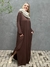 vestido longo, bem amplo, na cor marrom, tem um estilo despojado, a modelo usa uma gola de tricot bege para deixar o look mais elegante