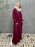 vestido longo, bem amplo, na cor marsala, tem um estilo despojado, a modelo usa uma gola de tricot bege para deixar o look mais elegante