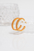 Argola aberta média cravejada com zircônias laranjas banhada a ouro 18k