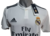 Camiseta de fútbol profesional Adidas del Real Madrid, color blanco, con logo y detalles de la marca.