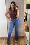 Modelo usando calça Jordana boot cut hot pants em jeans azul, com blusa marrom e acessórios elegantes.