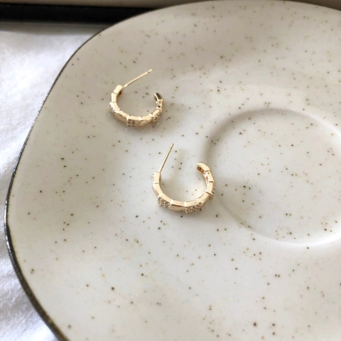 Brinco meia argola com detalhes de zircônias banhado a ouro 18k
