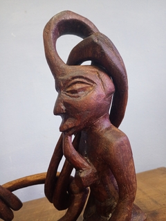 Escultura em africana esculpida em madeira representando casal unido por elos