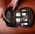 Organizador tech de couro Gatwick Texas aberto, mostrando compartimentos para tablet, mouse, carregador e cabos.