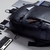 Mochila de couro masculina Pelli Brasil em couro preto, vista de frente sobre uma mesa com objetos em seu interior