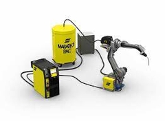Equipo de soldadura MIG con robot y tambores de material en un entorno industrial.