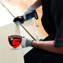 Operario utilizando una minipulidora GWS 12V-76 para cortar un material en un entorno de trabajo.