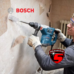 Un trabajador utilizando un martillo perforador demolador Bosch GBH 4-32 DFR para romper una pared.