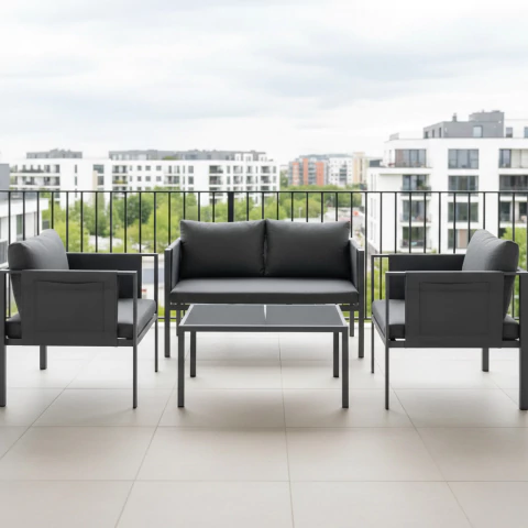 Set Exterior Moderno Bahía compuesto por dos sillones individuales, un sillón doble y una mesa ratona de aluminio y vidrio, ubicado en un balcón moderno con vista a edificios residenciales.