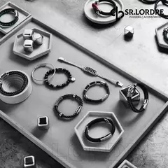 Pulseiras masculinas de couro e aço inoxidável dispostas em uma bandeja, incluindo a pulseira âncora.