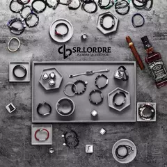 Pulseiras de couro e acessórios dispostos em uma bandeja, com destaque para a pulseira masculina de fitas de couro genuíno.