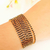 Pulseira larga com pedras pretas banhada em ouro 18k