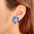 Brinco de flor com detalhe esmaltado azul banhado em ouro 18k - comprar online