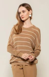 Modelo usando blusa oversized listrada bege da marca BIAMAR, com cabelo solto e brincos brancos.