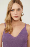 Modelo usando uma regata roxa animale de tricot com lurex, destacando o decote em V e alças finas.