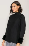 Mulher vestindo blusa feminina preta da marca BIAMAR com gola alta e aplicação de pele fake nos punhos