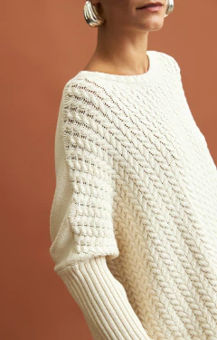 Capa Ambicione by anselmi de cor cru com gola removível, destacando o padrão de tricot e detalhes nas mangas.