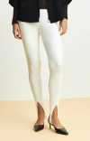 Calça feminina ambicione por anselmi fuseau canelada na cor off white, com recortes laterais, combinada com sapatos de salto preto.