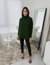 Modelo vestindo uma blusa ambicione por anselmi verde matcha com gola alta, combinando com calças pretas e sandálias de tiras, em ambiente moderno.