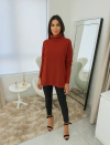 Modelo usando blusa ambicione por anselmi de gola alta na cor ferrugem, combinada com calças pretas e sandálias de salto.