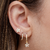 Brinco argolinha com pingente de flor cravejado folheado em Ouro 18k - comprar online