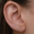 Brinco pequeno de U com micro zircônias cravejadas cor cristal folheado em ouro 18k