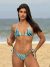 Biquíni conjunto Luna azul estampado canelado com top cortininha de bojo removível e calcinha de lacinho com amarração lateral, modelo posando na praia.