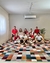 Grupo de pessoas sentadas em um tapete geométrico colorido na sala de estar.