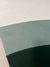 Tapete Kurve® em veludo com curvas em tons de verde e off-white.