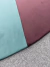 Tapete com bordas orgânicas nas cores Tiffany e Uva, sobre um fundo cinza texturizado.