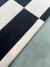 Tapete de veludo com listras alternadas em preto e off-white.
